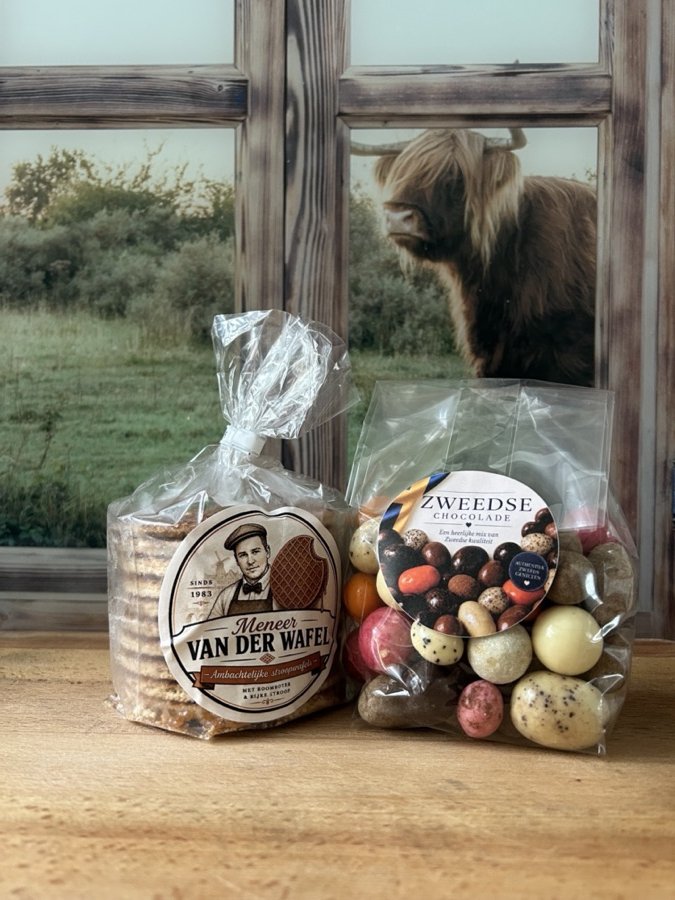 Een pakje stroopwafels en een zakje Zweedse chocolade voor het raam